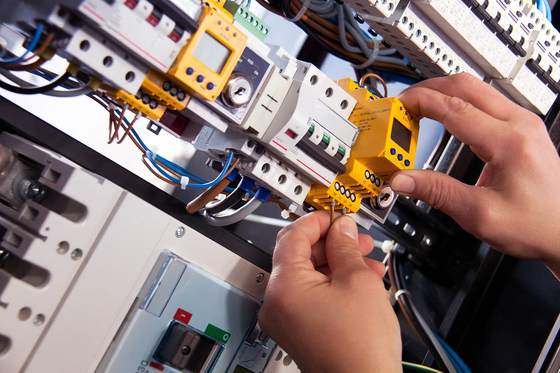 Elektromonteur die componenten in een verdeelkast aansluit