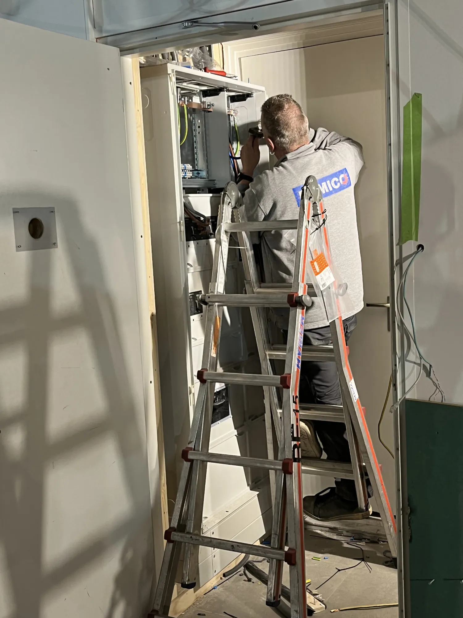 Bemico-monteur die een groepenkast installeert op locatie