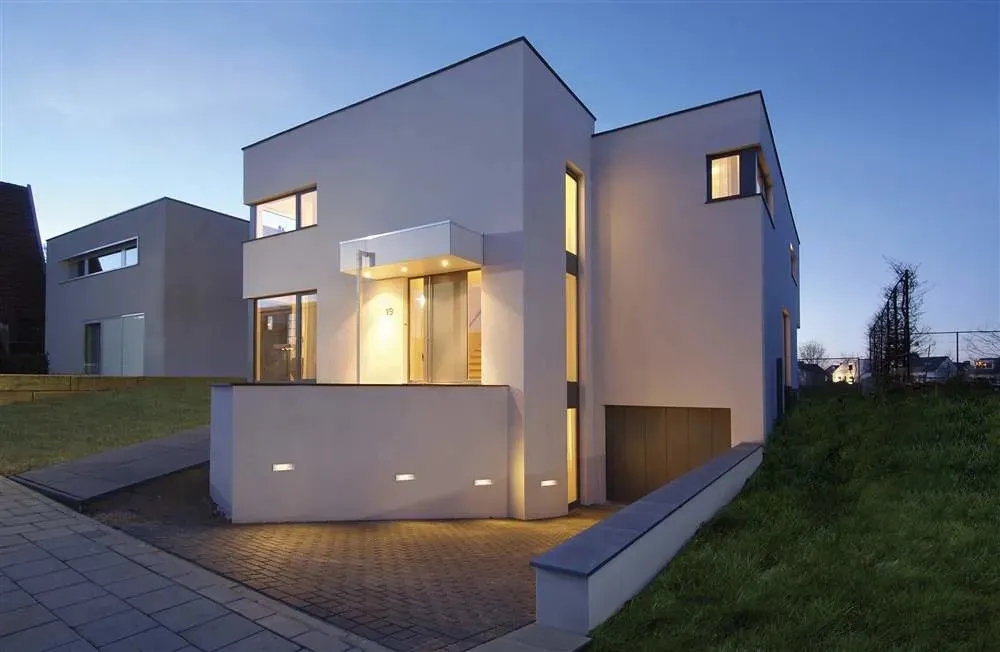 Moderne woning met architecturale buitenverlichting in de avond