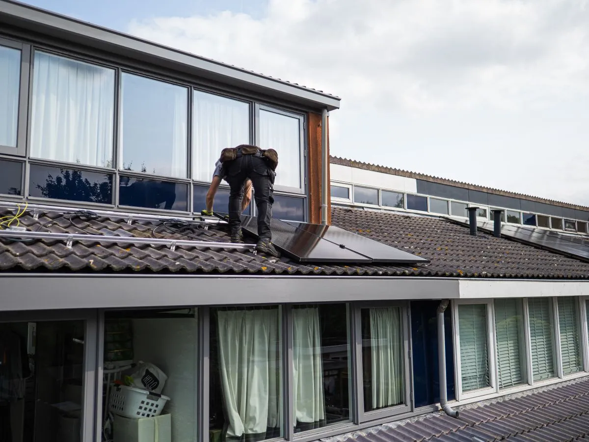 Monteur die zonnepanelen op een dak installeert